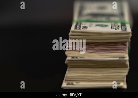 Ende auf zu einem grossen von USD Rechnungen mit Kopie Raum über einen dunklen Hintergrund in einem konzeptionellen finanzielle Bild Stapel Stockfoto