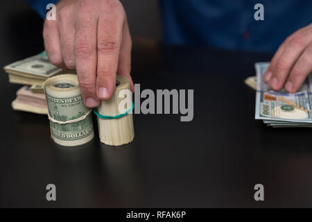 Unternehmer zählen rollt von USD-Banknoten in der Bereitschaft für Banken oder eine Barzahlung in Nahaufnahme auf seine Hände mit Kopie Raum Stockfoto