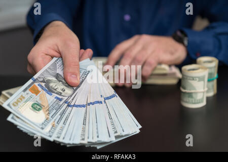 Geschäftsmann eine Zahlung oder ein Bestechungsgeld in einem Finanz- oder Korruption Konzept heraus halten, eine Handvoll Dollarnoten Stockfoto