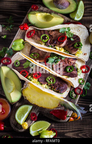 Traditionelle mexikanische Street Food - Rind Zunge Tacos mit Ananas salsa und Guacamole Stockfoto
