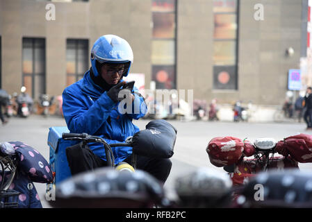 Peking, der chinesischen Provinz Shandong. 24 Jan, 2019. Deaktiviert Food Delivery Man Dong Hongxi Kontrollen sein Smartphone für eingehende Aufträge in Jinan, Provinz Shandong, China, Jan. 24, 2019. Credit: Wang Kai/Xinhua/Alamy leben Nachrichten Stockfoto