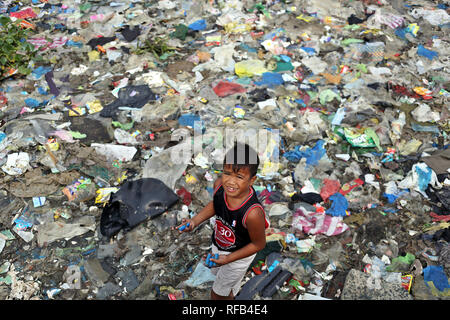 Manila, Philippinen. 30 Nov, 2018. Ein Junge ist auf der Suche nach gebrauchten Batterien in den Müll, am Ufer der Bucht von Manila angesammelt hat. Die philippinische Regierung die Sanierungsarbeiten am 27. Januar in der Bucht von Manila, des Landes am stärksten verschmutzten Wasser beginnen. Rund 200.000 Familien leben entlang der Bucht, die meisten von ihnen sammeln und Verkauf von Kunststoffen und Wertstoffen. Credit: Alejandro Ernesto/dpa/Alamy leben Nachrichten Stockfoto