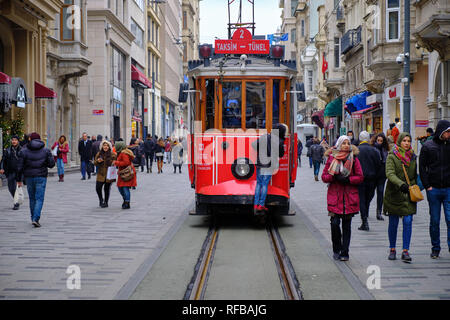 Istanbul, Türkei - rote Straßenbahn auf dem Weg durch die Massen von Käufern an der Independence Avenue. Kind reiten auf der Außenseite der Straßenbahn Stockfoto