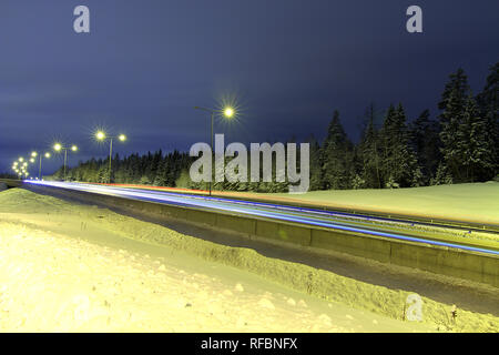 Leichte Wanderwege der Autos auf verschneiten Autobahn Stockfoto