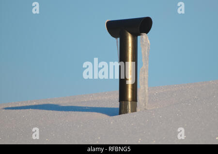 Gefrorene lüftung Rohr auf dem verschneiten Dach im Winter. Stockfoto