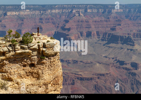 Ein Besucher auf eine ungeschützte Bergspitze sieht in den Grand Canyon in der Nähe von Mather Point, South Rim, Grand Canyon National Park, AZ, USA Stockfoto