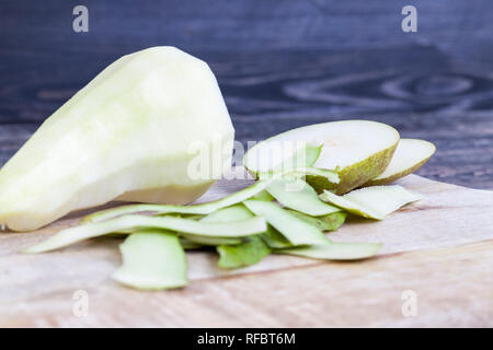 Geschälte Birnen liegen auf einem Schneidebrett aus Holz Stockfoto