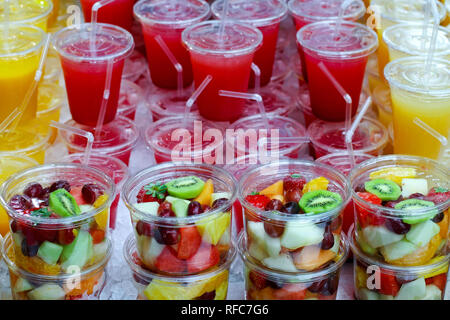 Haufen frisch zubereiteten Obstsalat und gepresste Säfte Stockfoto