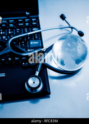 Glas Kugel und Stethoskop auf einer PC-Tastatur. blau getönten Bilder. Stockfoto