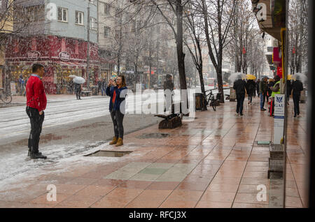 ESKİSEHİR, Türkei - Januar 15,2019: Schneefall in der Stadt. Die Menschen sind zu Fuß auf der Straße im Winter. Die Frau nehmen Sie Fotos ihrer Freundin unter Schnee und ma Stockfoto