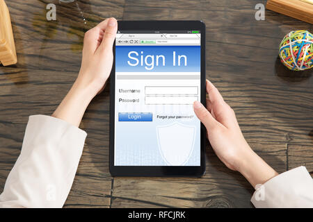 In der Nähe von Frau Anmeldung Website auf digitalen Tablet über Schreibtisch Stockfoto