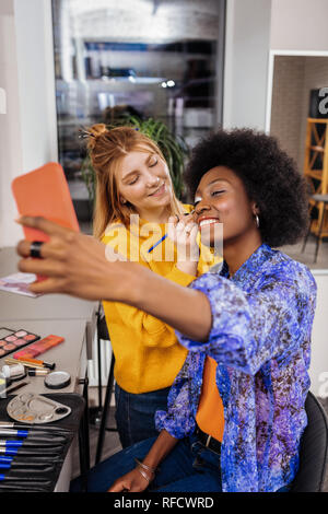Erstaunlich afrikanische amerikanische Modell mit korallenroten Lippenstift, selfie Stockfoto