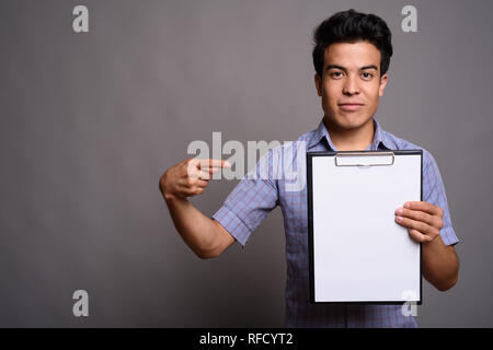 Portrait von jungen asiatischen Geschäftsmann gegen grauer Hintergrund Stockfoto