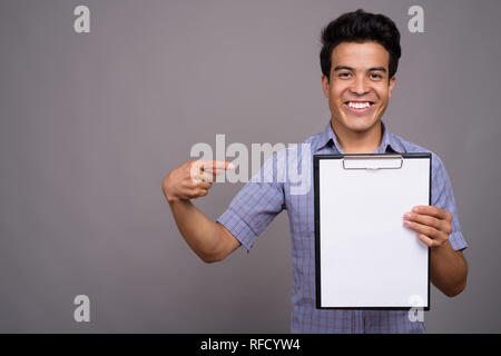 Portrait von jungen asiatischen Geschäftsmann gegen grauer Hintergrund Stockfoto