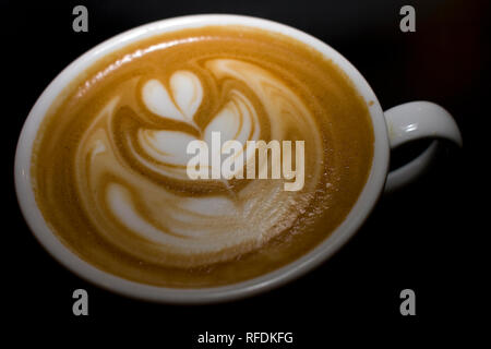 Latte Art in der Form eines Herzens auf eine Tasse Kaffee. Stockfoto