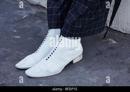 Mailand, Italien - Januar 14, 2019: Der Mann mit den weißen Schuhen und schwarz-weiß karierte Hose vor Spyder fashion show, Mailand Fashion Week Straße sty Stockfoto