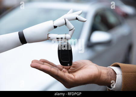 In der Nähe von einem Roboter die Hand mit dem Schlüssel zum Menschen Stockfoto