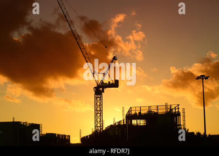 Kran auf der Baustelle bei Sonnenuntergang auf die Skyline der Stadt Leeds yorkshire United Kingdom Stockfoto