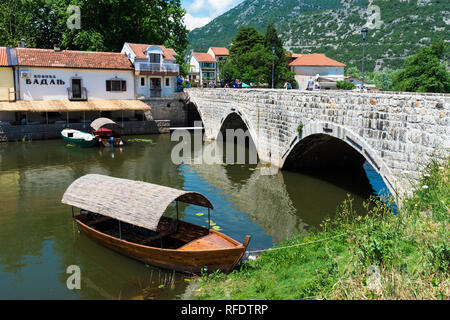 Touristenboot in der Nähe einer römischen Brücke verankert, Skutarisee, Virpazar, Montenegro Stockfoto