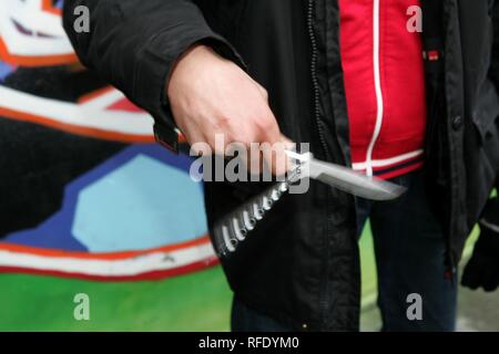 DEU, Deutschland: Jugendkriminalität. Junger Mann spielt mit seinem flick Messer. (gestellte Szene) | Stockfoto