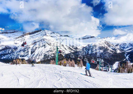 Nicht identifizierbare Skifahrer und Snowboarder auf dem Sessellift auf einer Skipiste in die verschneite Bergwelt der Kanadischen Rockies. Stockfoto