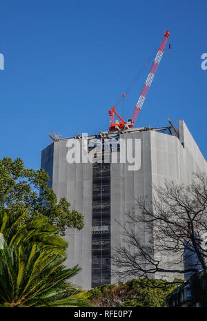 Baukran auf der Baustelle mit Abdeckung für Sicherheit in Hiroshima, Japan. Stockfoto