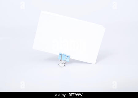 Portrait von weißen Grußkarte mit Büroklammer befestigen. Auf den weißen Hintergrund isoliert. Stockfoto