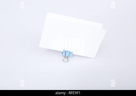 Bild der Weißen Grußkarte mit Büroklammer befestigen. Auf den weißen Hintergrund isoliert. Stockfoto