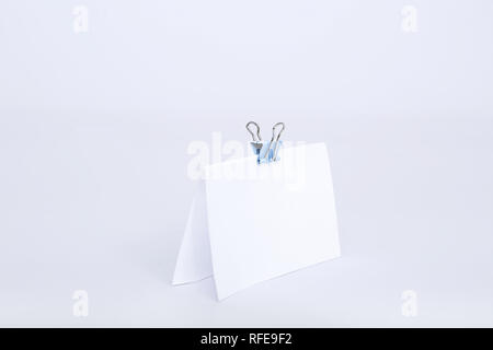 Portrait von leere weiße Karte mit Büroklammer befestigen. Auf den weißen Hintergrund isoliert. Stockfoto