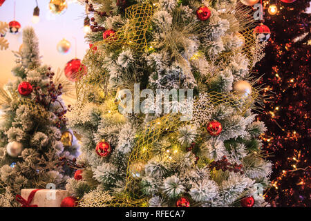 Bunte Rot, Gold und Silber hängenden Glitzernde Kugel Kugeln Hintergrund dekoriert mit schneereichen Winter Weihnachtsbaum in der Shopping Mall. Besonderen Urlaub, Stockfoto