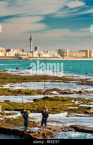 Cadiz, Spanien - Dez, 2018: Männer die Fischerei die Felsen des Paseo Fernando Chinone Stockfoto