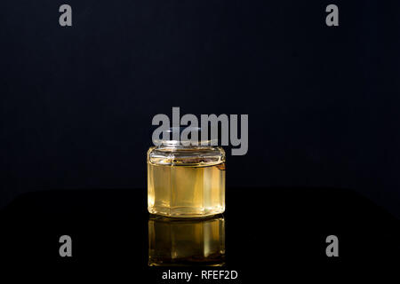 Trüffel Pilz in ein Glas Honig auf schwarzem Hintergrund. Minimalismus in der Komposition. Luxus essen. Freier Platz für Text Stockfoto