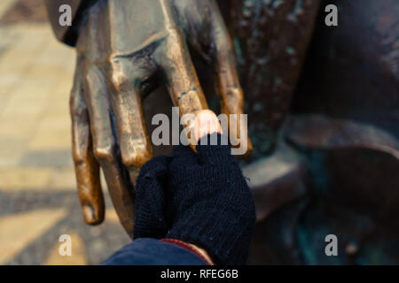 Junge hand Walzenaufnahme Hans Christian Andersen Statue. Das Berühren der Statue soll Glück bringen. Stockfoto