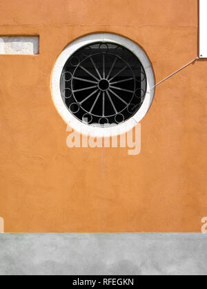 Rose Fenster mit Gitter auf orange Wand Stockfoto