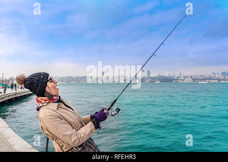 Schöne Frau Fänge Fische am Bosporus, ein beliebtes Ziel im Uskudar Stadt, Istanbul, Türkei Stockfoto