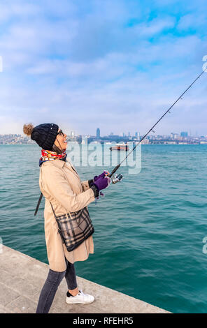 Schöne Frau Fänge Fische am Bosporus, ein beliebtes Ziel im Uskudar Stadt, Istanbul, Türkei Stockfoto