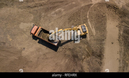 Luftbild des Baggers gießt Sand in den Wagen. Stockfoto