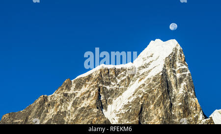 Mond über dem sonnenbeschienenen und schneebedeckten Taboche Bergspitze, von Dingboche, Sagarmatha, Nepal Stockfoto
