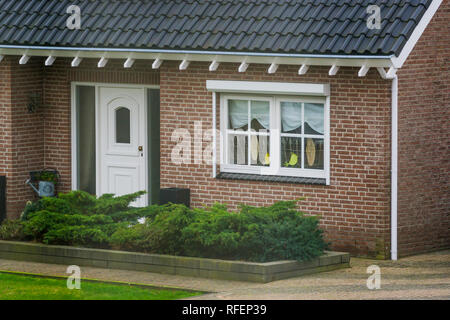 Vordere äußere eines luxuriösen niederländische Bungalow mit Garten, Vordertür mit geschmückten Fenster, Haus in einem kleinen Dorf in den Niederlanden Stockfoto