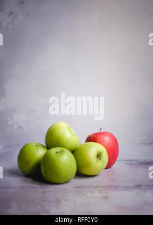 Vier grüne Äpfel und einen roten Apfel Stockfoto