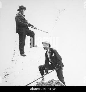 Ein Ende des 19. Jahrhunderts schwarz-weiß Foto mit der berühmten Schweizer Bergführer, Peter Kaufmann. Peter Kaufmann (17. Januar 1858, in Grindelwald - Oktober 14, 1924, in Grindelwald, im Alter von 66 Jahren) war ein Schweizer Bergführer während das Silberne Zeitalter des Alpinismus (1865-1882) und am Anfang des zwanzigsten Jahrhunderts, der Amateure, erfahrene Bergsteiger, und mehrere Honoratioren über Gletscher, über Pässe, und zu den Gipfeln der Schweizer Alpen, die Kanadischen Rocky Mountains und den Selkirks. Ein jüngerer Mann kann auf den verschneiten Hang direkt unter ihm gesehen werden. Stockfoto