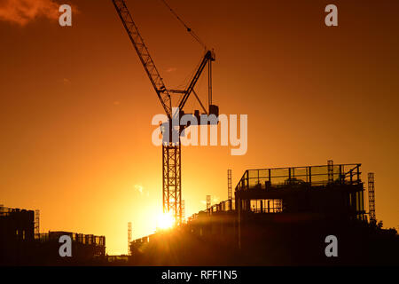 Kran auf der Baustelle bei Sonnenuntergang auf die Skyline der Stadt Leeds yorkshire United Kingdom Stockfoto