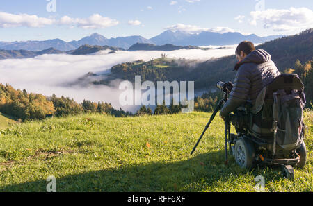 Mann auf Rollstuhl Fotos von schönen Landschaft in einer nebligen Morgen, St. Thomas, Slowenien Stockfoto