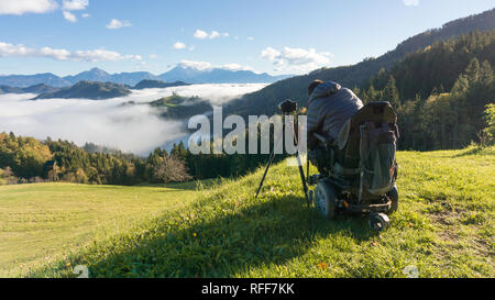 Mann auf Rollstuhl Fotos von schönen Landschaft in einer nebligen Morgen, St. Thomas, Slowenien Stockfoto