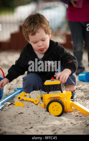 Kleinkind spielen in einer Sandkuhle Stockfoto