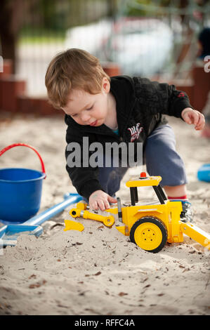 Kleinkind spielen in einer Sandkuhle Stockfoto