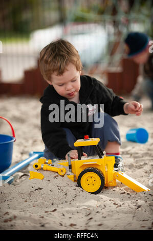 Kleinkind spielen in einer Sandkuhle Stockfoto