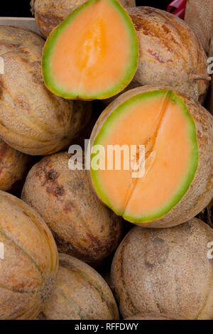 Bündel von organischen Melonen, und ein in der Hälfte zeigt seine orange Fleisch, auf Verkauf am Wochenmarkt in Serbien angezeigt, Detail Stockfoto