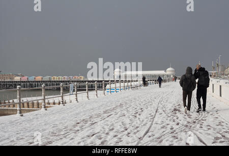 Menschen wandern im Schnee entlang der Strandpromenade in Hastings, East Sussex, Großbritannien Stockfoto