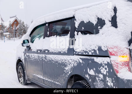 Closeup grau Minibus schmutziges Auto mit Schnee auf der Stadt abgedeckt. Von der Seite. Konzept, Schnee, Schneefall, schlecht nördlichen Wetterbedingungen, niedrig Stockfoto